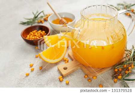 Warming sea buckthorn tea with orange slices and honey 131370528
