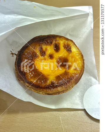 Golden egg tart with a flaky, buttery crust and a rich, creamy custard center. A deliciously satisfying treat for dessert or a light snack, blending texture and flavor perfectly. 131370577