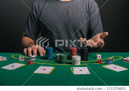 Man dealer or croupier shuffles poker cards in a casino game card, and chips on green table Man dealer or croupier shuffles poker cards in a casino game card, and chips on green table 131370601