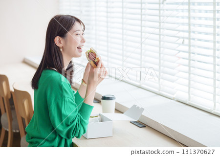 A woman eating a sandwich 131370627
