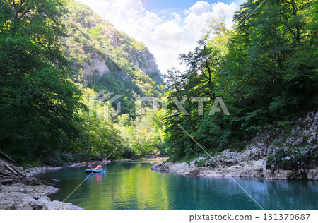 Famous tourist attraction - is rafting on Tara river. Picturesque view of Tara canyon, Montenegro. Excursion on inflatable boats along Tara river. Topic of summer vacation, travel, active tourism Famous tourist attraction - is rafting on Tara river. Picturesque view of Tara canyon, Montenegro. Excursion on inflatable boats along Tara river. Topic of summer vacation, travel, active tourism 131370687