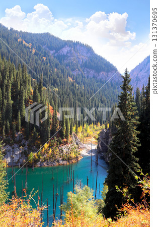 Picturesque autumn scenery of Kaindy lake with dead trees, Kolsay Lakes National Park, northern region of Tien Shan Mountains, Kazakhstan. Alpine Kaindy lake, Almaty region, Kazakhstan Picturesque autumn scenery of Kaindy lake with dead trees, Kolsay Lakes National Park, northern region of Tien Shan Mountains, Kazakhstan. Alpine Kaindy lake, Almaty region, Kazakhstan 131370695