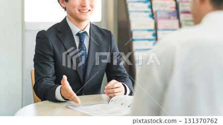 A young Asian businessman negotiating, serving and meeting with a male customer (car/insurance) 131370762