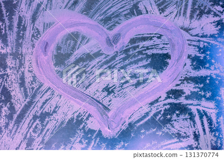 Heart shape on a frozen window. Abstract photo background in pink light. Valentine's day and love concept Heart shape on a frozen window. Abstract photo background in pink light. Valentine's day and love concept 131370774