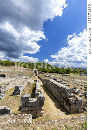 Ancient Roman ruins standing under large clouds in L'Aquila 131371520