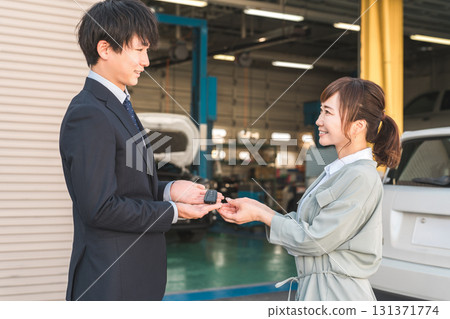 銷售員從女顧客手中拿走車鑰匙，男銷售員 131371774