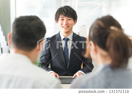 Young Asian businessman serving a couple Young Asian businessman serving a couple 131372118