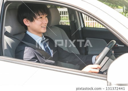 穿著西裝駕駛汽車的年輕男性商人 131372441