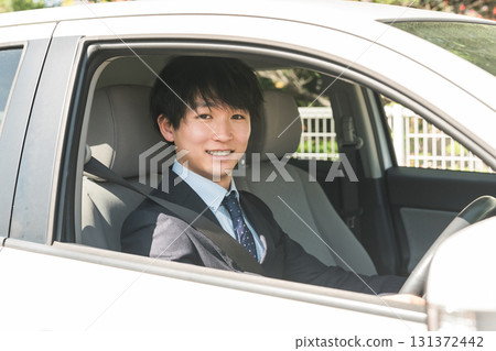 穿著西裝駕駛汽車的年輕男性商人 131372442