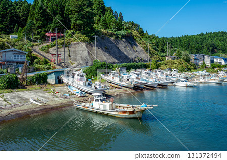 Scenery of a fishing village and small fishing port clinging to the foot of the mountain 131372494