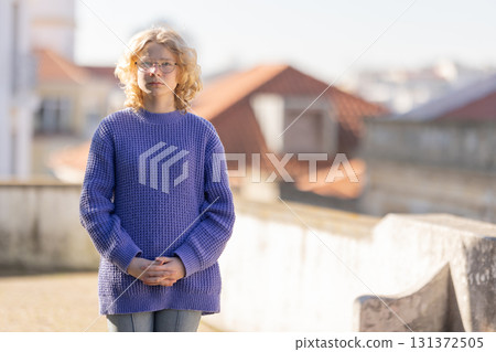 Young woman with glasses standing on rooftop Young woman with glasses standing on rooftop 131372505