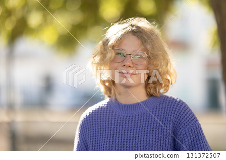 Young person smiling wearing glasses in sunlight 131372507