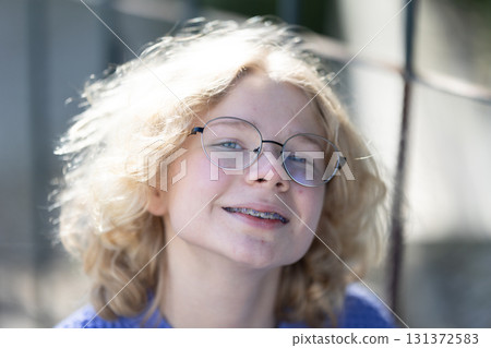 Young person smiling with glasses and braces 131372583