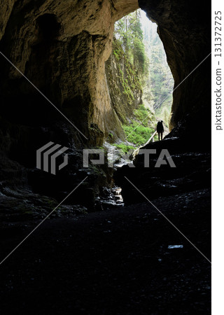 Silhouette of cave entrance from inside with a spelunker 131372725