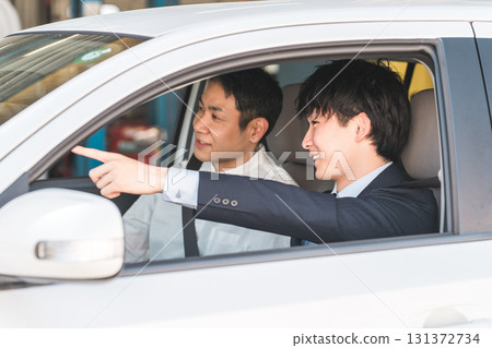 A middle-aged male driver taking a class to obtain a driver's license and a teacher at a driving school A middle-aged male driver taking a class to obtain a driver's license and a teacher at a driving school 131372734