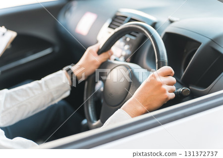 A middle-aged male driver taking a class to obtain a driver's license and a teacher at a driving school A middle-aged male driver taking a class to obtain a driver's license and a teacher at a driving school 131372737