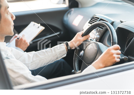 A middle-aged male driver taking a class to obtain a driver's license and a teacher at a driving school A middle-aged male driver taking a class to obtain a driver's license and a teacher at a driving school 131372738