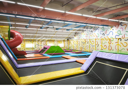 Colorful indoor trampoline park with slides, mats, and fun play areas for kids and families. Perfect for recreation, parties, and active entertainment.  131373078