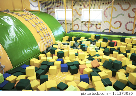 Colorful indoor soft play area with foam cubes and a climbing structure, perfect for kids' fun, games, and parties in a safe, bright environment. High quality photo Colorful indoor soft play area with foam cubes and a climbing structure, perfect for kids' fun, games, and parties in a safe, bright environment. High quality photo 131373080