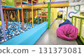 Children's entertainment area, a bright indoor playground with safe climbing frames, colorful obstacles, a pool with blue and white balls, and beanbag chairs for relaxing. High quality photo 131373081