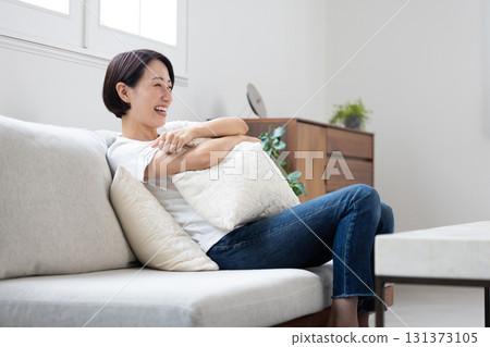 Smiling woman relaxing on the sofa 131373105