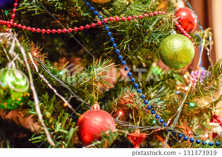 Decorations New Year tree. Tinsel and toys, balls and other decorations on the Christmas Christmas tree standing in the open air. Decorations New Year tree. Tinsel and toys, balls and other decorations on the Christmas Christmas tree standing in the open air. 131373919