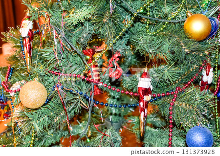 Decorations New Year tree. Tinsel and toys, balls and other decorations on the Christmas Christmas tree standing in the open air. Decorations New Year tree. Tinsel and toys, balls and other decorations on the Christmas Christmas tree standing in the open air. 131373928