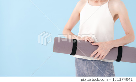 Woman holding a yoga mat 131374041