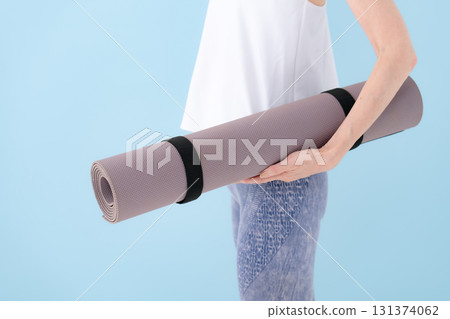 Woman holding a yoga mat 131374062