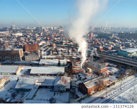 Winter town. Frosty sunny day in the city. Snow on the streets and smoke from the boiler rises. Frost and sun, a wonderful day 131374126