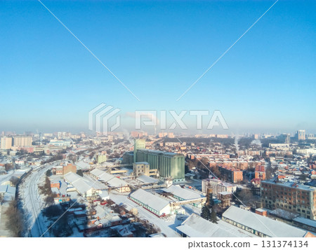 Winter town. Frosty sunny day in the city. Snow on the streets and smoke from the boiler rises. Frost and sun, a wonderful day Winter town. Frosty sunny day in the city. Snow on the streets and smoke from the boiler rises. Frost and sun, a wonderful day 131374134