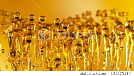 Freeze Motion of Abstract Oil Splashes on Golden Background. Oil Drops Flying up in the Air. Concept of Beauty, Serum, Fuel or Fry. Freeze Motion of Abstract Oil Splashes on Golden Background. Oil Drops Flying up in the Air. Concept of Beauty, Serum, Fuel or Fry. 131375114