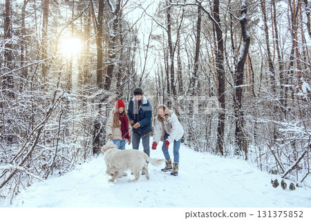 Cute young family and their dog spending day in winter forest Cute young family and their dog spending day in winter forest 131375852