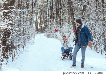Man pulling sled with his wife and both feeling excited 131375881