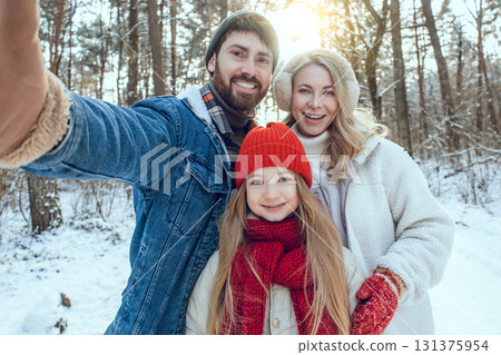 Cute young family enjoying and having fun in a winter forest 131375954