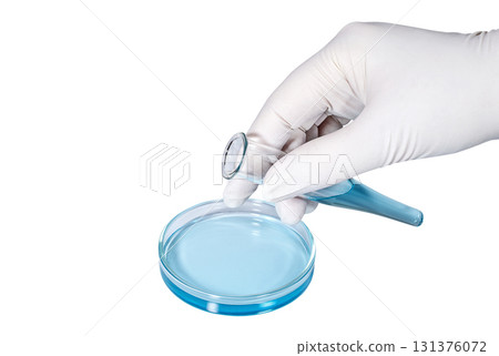 Hand in medical latex glove with a test tube filled with blue liquid 131376072