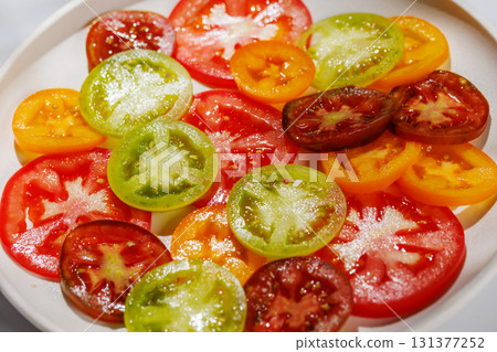 Colorful sliced tomatoes on a plate, fresh and vibrant Colorful sliced tomatoes on a plate, fresh and vibrant 131377252