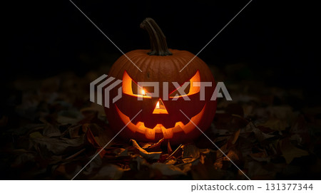 Halloween pumpkin carved with a sinister face illuminated by candlelight at night 131377344