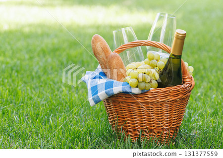 Picnic basket with wine, grapes, and baguette Picnic basket with wine, grapes, and baguette 131377559