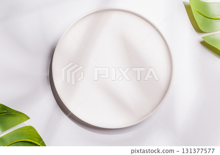 Empty plate on white background with leaves and shadows, food mockup with natural light 131377577