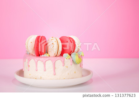 A beautifully decorated cake adorned with colorful macarons 131377623