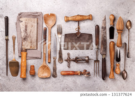 A collection of various retro kitchen and cooking utensils displayed on a table A collection of various retro kitchen and cooking utensils displayed on a table 131377624