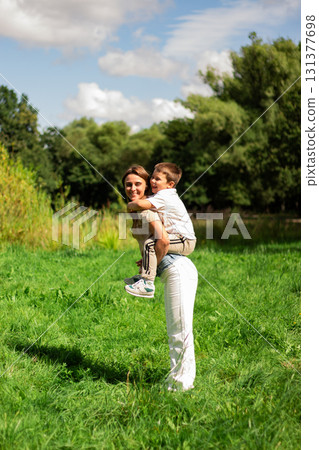 Playful parenting moment. Mom and preschool son dance and play together outside on summer day. Perfect illustration of carefree childhood joy. Playful parenting moment. Mom and preschool son dance and play together outside on summer day. Perfect illustration of carefree childhood joy. 131377698