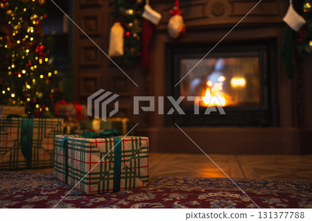 Green gift box in classical Christmas decorated interior living room library with fireplace. Christmas gift near fir tree on Christmas eve. Modern classic style interior design apartment. Christmas 131377788