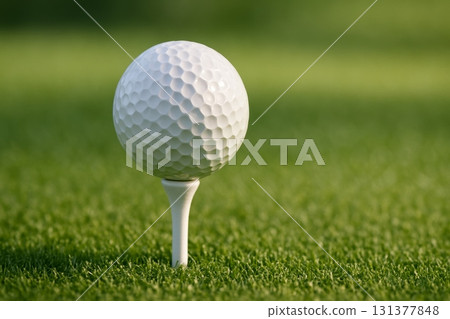 Close-up of white golf ball on tee, set on fresh green grass, ready for golf shot in outdoor sports environment, copy space. 131377848