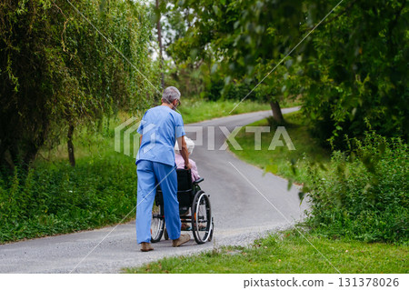 Male home nurse taking care of elderly woman in wheelchair. 131378026