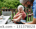 Home nurse checking glucose level of senior lady with smartphone. 131378028