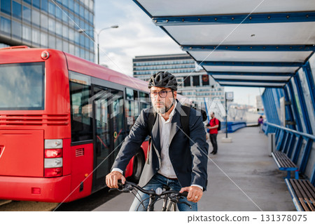 City commuter riding bike to office, wearing backpack and helmet. 131378075
