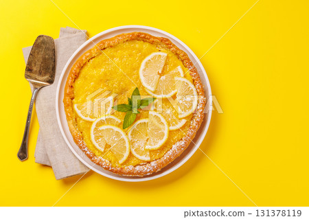 Delicious lemon tart with golden crust and smooth, glossy lemon filling 131378119