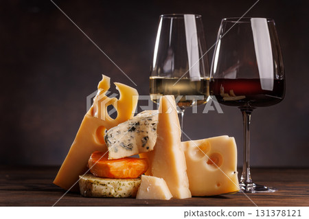 Assorted cheeses paired with glasses of wine on a rustic table Assorted cheeses paired with glasses of wine on a rustic table 131378121